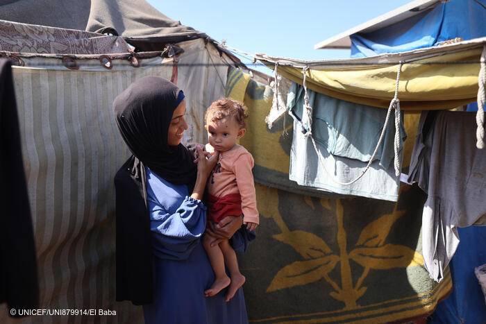 Rania sostiene a su hija Lareen fuera de su tienda improvisada en Al-Mawasi, en la Franja de Gaza.