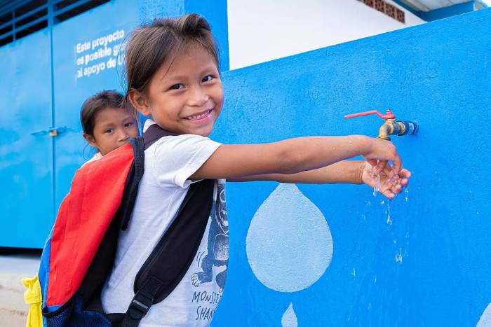 Una niña se lava las manos con agua limpia, Venezuela.