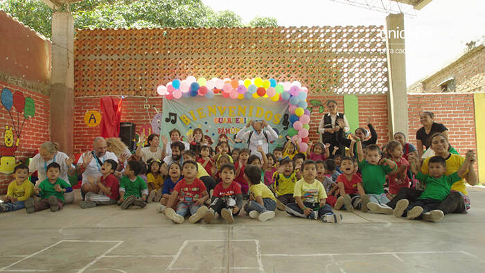 Los socios de UNICEF viajan a Bolivia y posan en una escuela con niños y niñas