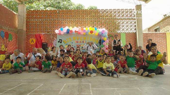 Los socios de UNICEF viajan a Bolivia y posan en una escuela con niños y niñas