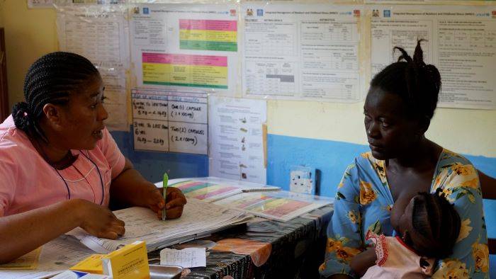 Zainab Swaray, habla en consulta con una trabajadora de salud sobre los cuidados de su hija.