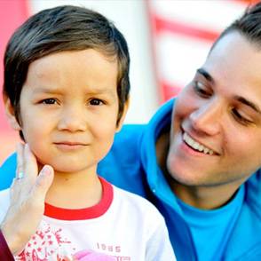 Un niño con una persona de UNICEF