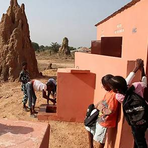 Niños frente a unas letrinas