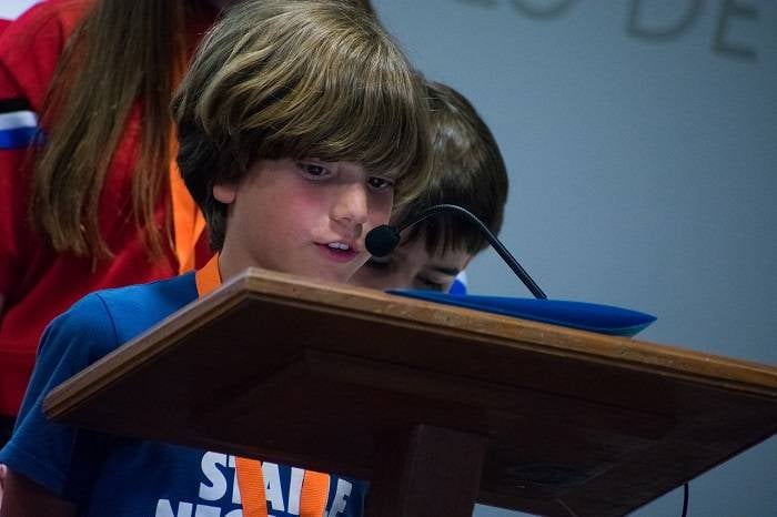 Un niño lee en un atril