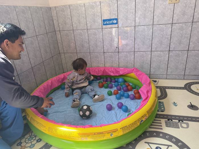 Un niño con su padre en un centro de atención temprana de UNICEF.