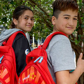 Dos niños con mochilas escolares