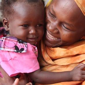 Una niña cuidando de su bebé en brazos