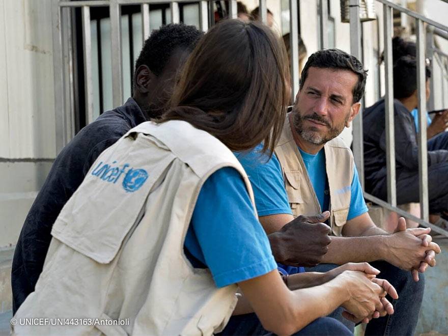 Miembros del staff de UNICEF hablan con una persona refugiada
