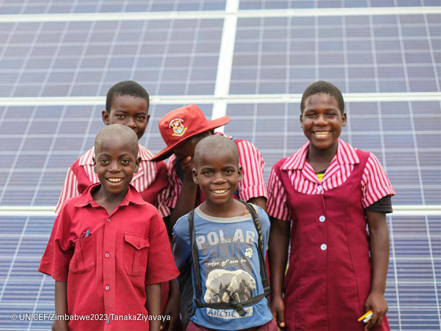 Energía solar para combatir la brecha digital. Niños frente a una placa solar.
