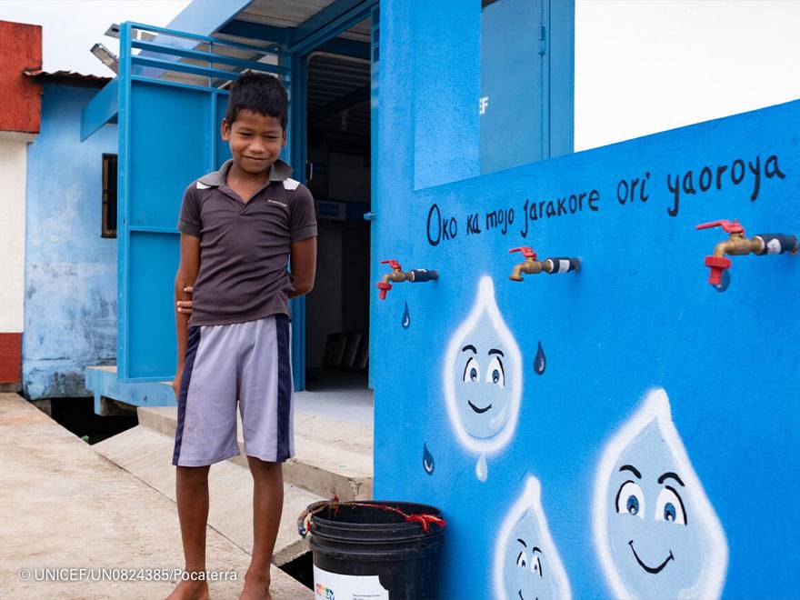 Niño de Venezuela junto a una instalación de saneamiento