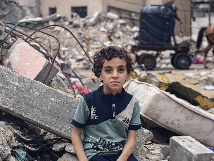 Mohammad de 8 años, posa en Gaza, entre los escombros