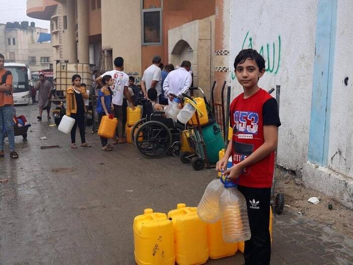 Ahmad espera con varias garrafas para recoger agua