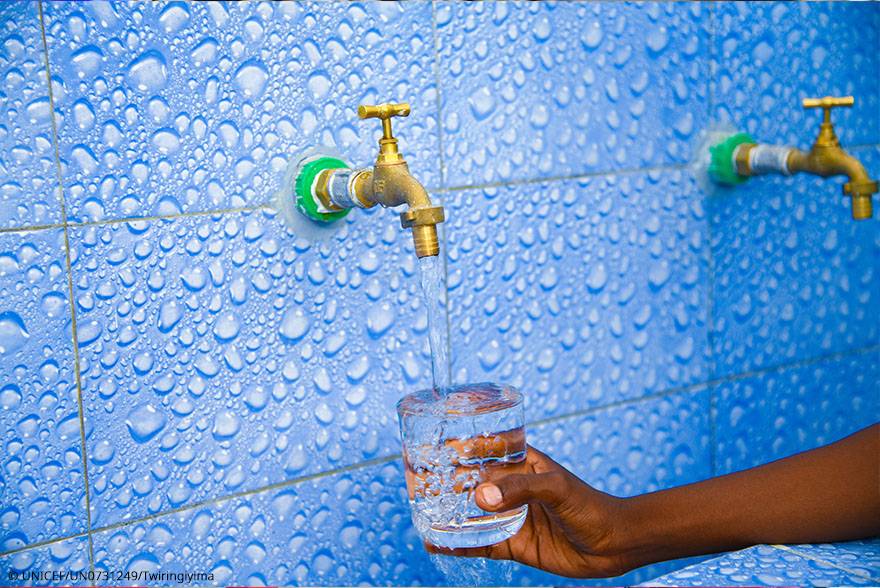 Agua en las escuelas Una niña llena un vaso de agua en el baño de su escuela, en República Democrática del Congo