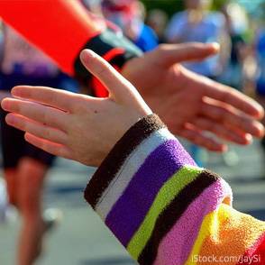 Carreras solidarias en colegios Dos participantes de una carrera chocan sus manos