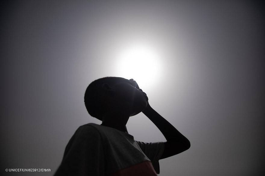 Ali, de 10 años, se protege el rostro del sol con la mano en Sudán